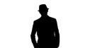 Silhouette Young Asian tourist man wearing hat walking with hands in pockets. Royalty Free Stock Photo