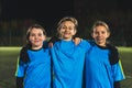 medium shot of three young girls in football blue sportswear taking a photo together Royalty Free Stock Photo