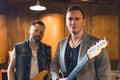 medium shot of two guitarists of a music band posing on repetition, music concept recording studio Royalty Free Stock Photo