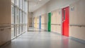 Medium shot of a wide hallway featuring sturdy handrails and brightly colorcoded doors under natural daylight for Royalty Free Stock Photo