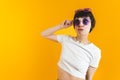 Medium shot of a woman in white top wearing two pairs of sunglasses - one on her nose and another on the top of her head Royalty Free Stock Photo