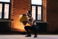 Medium shot of young athletic woman with strong body wearing sportswear doing squats with heavy medicine ball during Royalty Free Stock Photo