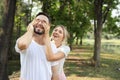 Medium shot, young lovely couple caucasian in white dress playing blindfolded with happy face and laughing in park outdoor during Royalty Free Stock Photo