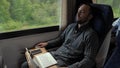 Young man sleeping while traveling on a train. Royalty Free Stock Photo