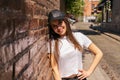 Medium shot of a young teenage girl leaning against a brick wall Royalty Free Stock Photo