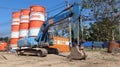 Medium-size hydraulic excavator near steel silos