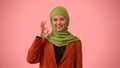 Medium-sized isolated photo capturing an attractive young woman wearing a hijab, veil. She is showing an OK gesture