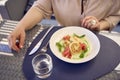 a medium sized woman in peach fuzz dress eating cottage cheese pancakes with salmon and spinach in modern restaurant Royalty Free Stock Photo