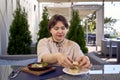 medium sized woman in peach fuzz dress eating Shakshouka in modern restaurant