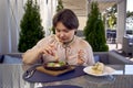 medium sized woman in peach fuzz dress eating Shakshouka in modern restaurant