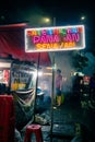 Indonesian taichan satay street vendors with neon sign during the night