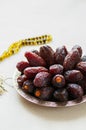 Medjoul - dried dates or kurma in a vintage plate and rosary Royalty Free Stock Photo