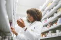 The meds we sell is of the best quality. a cheerful young female pharmacist reading the label of a medication bottle Royalty Free Stock Photo