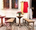 Meedieval houses and wooden table with  flowers bench vintage dresses on shop windows street scene in Tallinn old town Travel to E Royalty Free Stock Photo