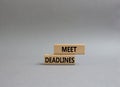 Meet Deadlines symbol. Concept word Meet Deadlines on wooden blocks. Beautiful grey background. Business and Meet Deadlines Royalty Free Stock Photo