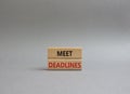 Meet Deadlines symbol. Concept word Meet Deadlines on wooden blocks. Beautiful grey background. Business and Meet Deadlines Royalty Free Stock Photo