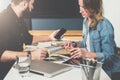 Meet one-on-one. Business meeting. Teamwork. Businessman and businesswoman sitting at table. Man using smartphone Royalty Free Stock Photo