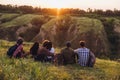 Meet sunset. Group of friends, young men and women walking, strolling together during picnic in summer forest, meadow Royalty Free Stock Photo