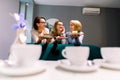 Meeting with best friend. Horizontal shot of beautiful three women talking while drinking coffee with desserts in Royalty Free Stock Photo