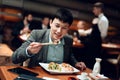 Meeting with chinese businessmen in restaurant. Man is eating sushi. Royalty Free Stock Photo