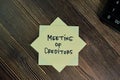 Meeting of Creditors write on sticky notes isolated on Wooden Table Royalty Free Stock Photo