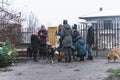 Meeting of dog shelter voluntary workers next to the fence exit. Group of volunteers in warm clothes gets ready to walk Royalty Free Stock Photo