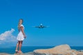 Meeting of Elements: White Dress, Blue Sea, Stones, and the Flying Plane