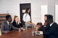 Personable business people in formal wear sit together in office