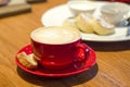 Meeting of lovers on Valentine`s Day. cappuccino with lush foam and pattern in red ceramic cup