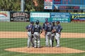 A meeting on the Mound as Seen from Behind the Backstop