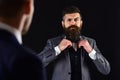 Meeting of reputable businessmen, black background. Man with beard on serious face, ties bow tie before meeting