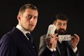 Meeting of reputable businessmen, black background. Man on serious face hold roll made out of dollar, money, pay to Royalty Free Stock Photo