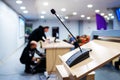 Meeting room microphone. Technical workers are preparing equipment for the conference. Blurred background. Unrecognizable faces