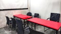 Meeting Room in Office with Two Red Tables, Black Chairs and White Board Royalty Free Stock Photo