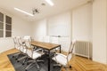 Meeting room with wooden office table with metal frame and swivel chairs upholstered in white skai, whiteboard for erasable Royalty Free Stock Photo