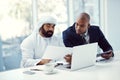 Meeting to make success happen. two businessmen using a digital tablet and laptop while having a discussion in a modern Royalty Free Stock Photo