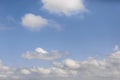 Meeting of two angelic white and fluffy clouds with menacing gray-white dense cumulus clouds on a white-blue soft morning sky Royalty Free Stock Photo