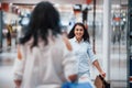 Meeting of two female friends in the mall at weekend shopping time Royalty Free Stock Photo