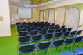 Meeting zone in the office in a loft style with white brick walls and concrete columns. Zone has a large wooden table with gray