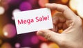 Mega Sale - the inscription on the card that the person is holding