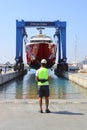 The mega yacht is lifted by a large crane with the operator\'s control for maintenance on land. Selective Focus.