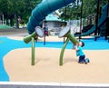 Megaphone? Bongos? A little boy shouts into the end of large playground bongos at Guelph Riverside park playground