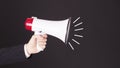 Megaphone . Close-up of human hand holding megaphone against blackboard Royalty Free Stock Photo