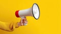 The megaphone held firmly in hand on vibrant yellow background AI generated image Royalty Free Stock Photo