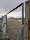 A megapolis outskirts revealling a jagged line of skyscrappers in the open gate of a construction zone