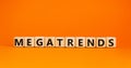 Megatrends symbol. The word megatrends on wooden cubes. Beautiful orange table, orange background. Business and megatrends concept