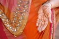 Mehendi on his hands again  Indian bride dressed in Hindu red traditional wedding clothes lehenga embroidered with gold and a veil Royalty Free Stock Photo