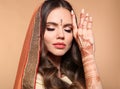 Mehendi. Portrait of beautiful indian girl in saree isolated on beige. Young hindu woman model with kundan golden jewelry set. Royalty Free Stock Photo