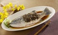 Meicai steamed fresh water fish grouper with sauce on white plat