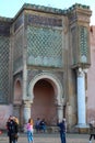 A fragment of the main and most beautiful gate of Meknes Bab-El-Mansur and tourists photographing them
